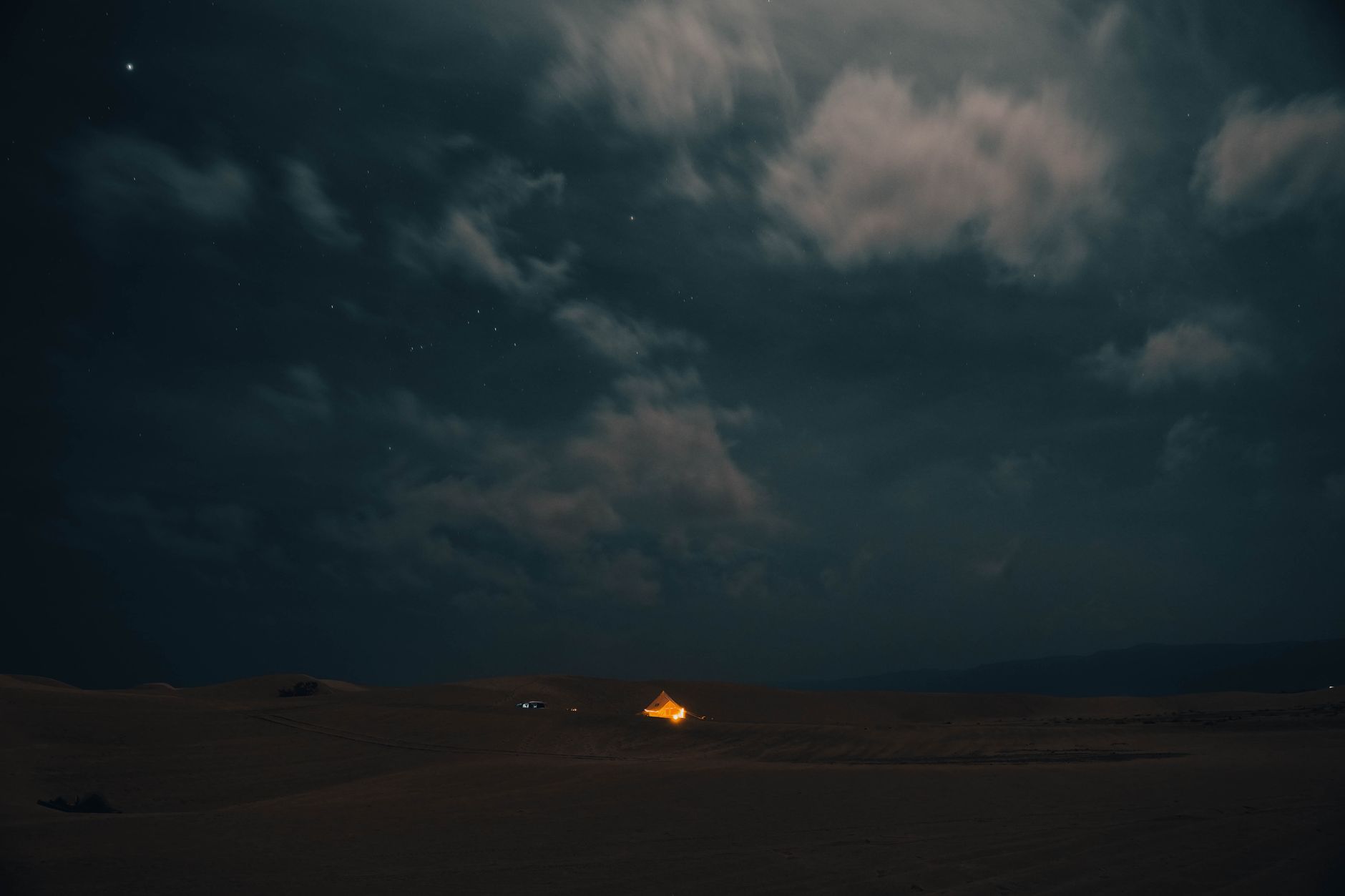 帐篷内望向夜空,帆布门帘半卷,银河隐约可见